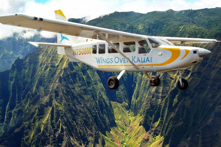 Wings Over Kauai's AirVan tour plane flying over Honopu